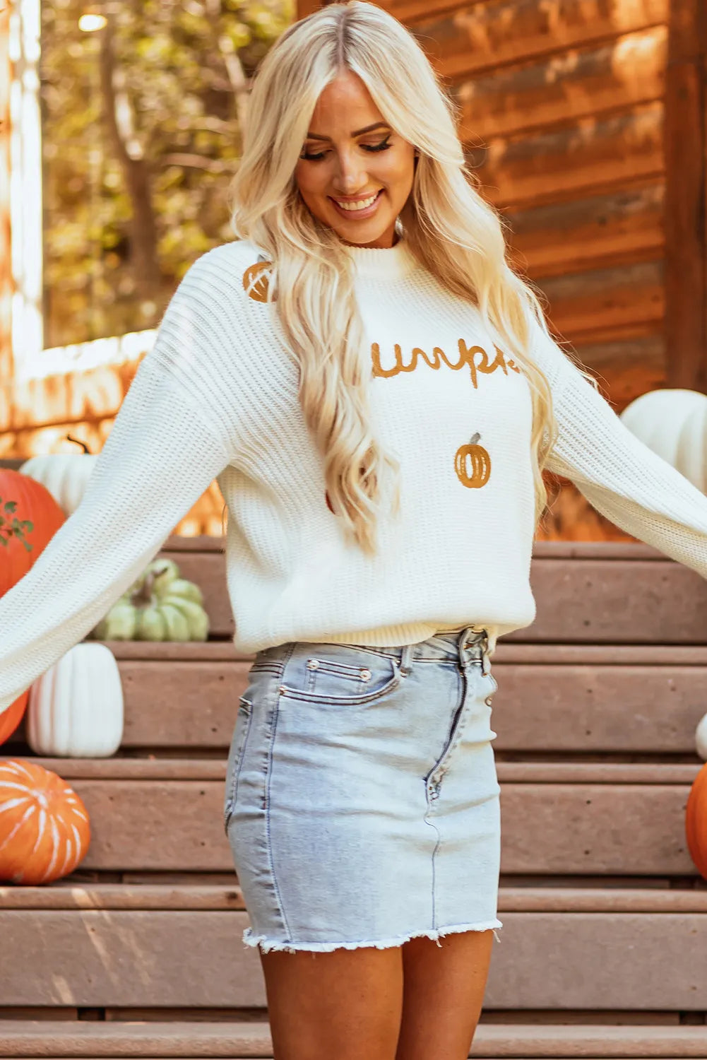 Front view of pumpkin embroidery detail on white knit sweater