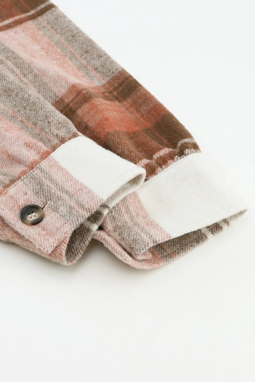 Sleeve detail of plaid shacket showing button cuff design
