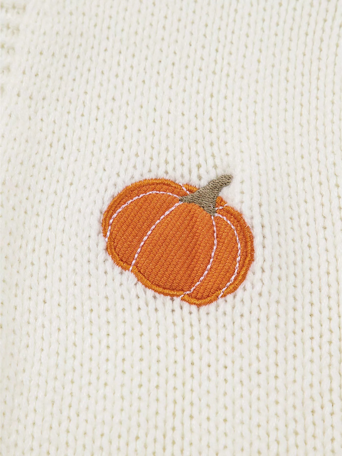 Close-up of embroidered pumpkin detail on knit cardigan