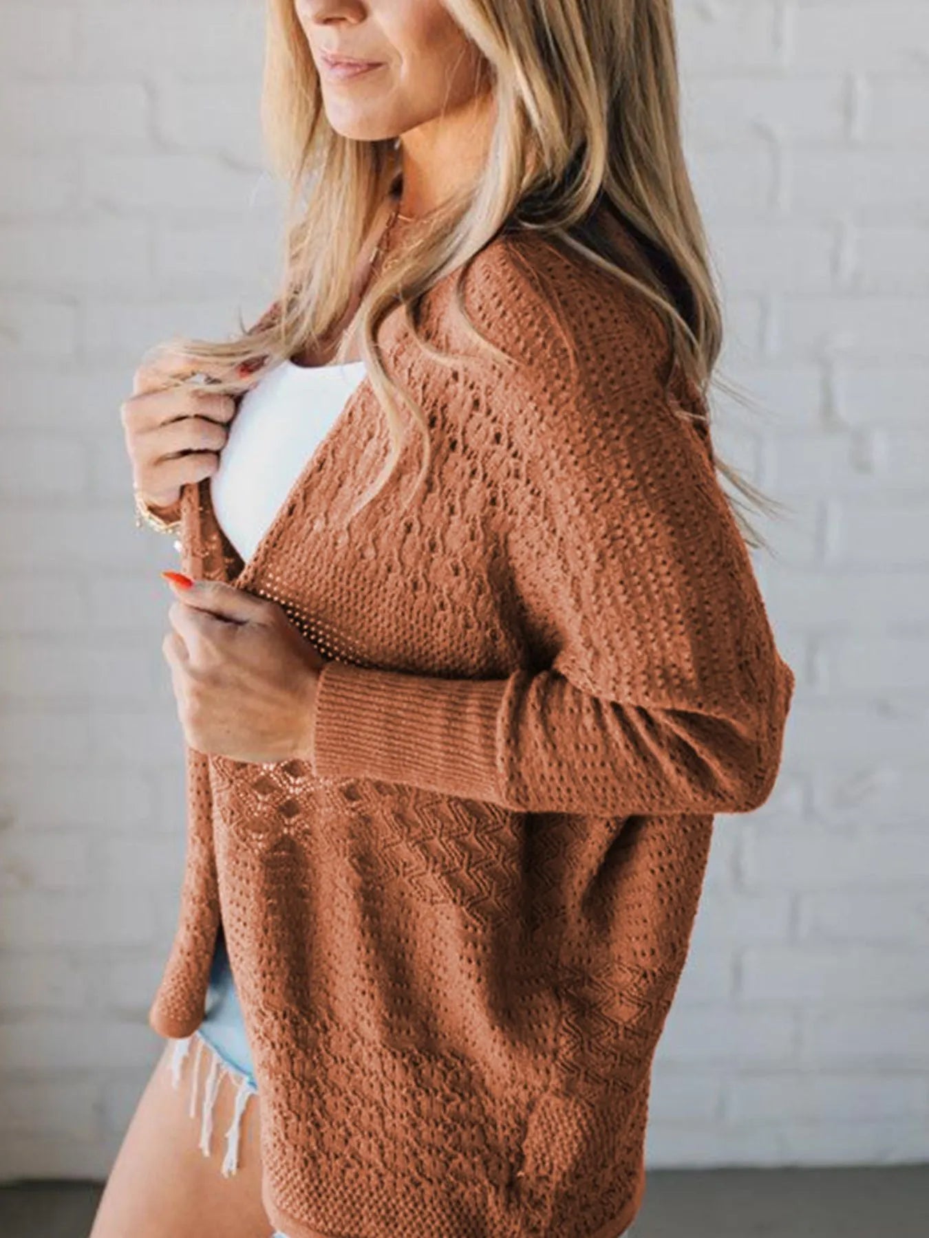 Side view of brown knitted cardigan with open front and long sleeves
