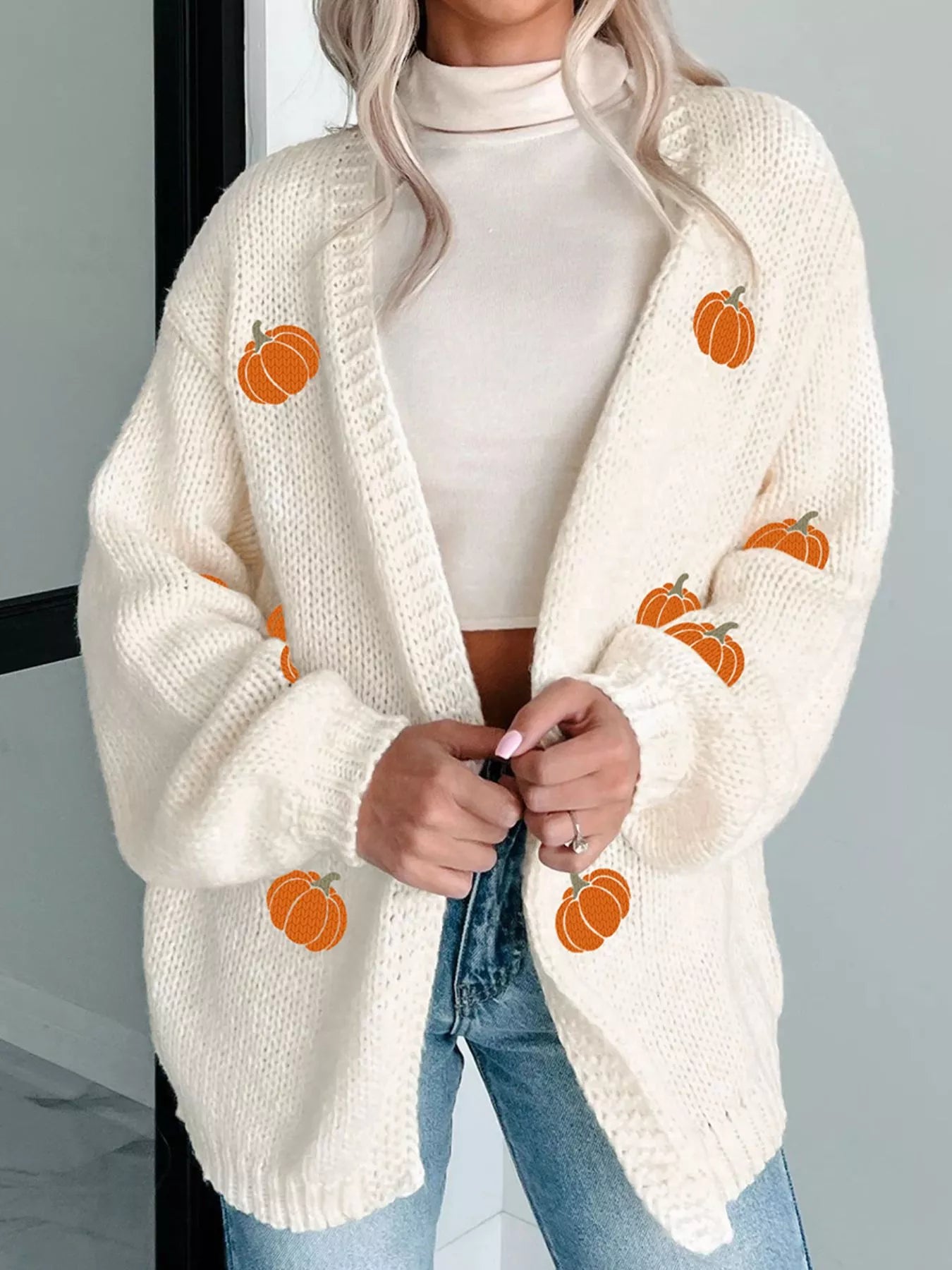 Front view of festive pumpkin cardigan with cozy knit design