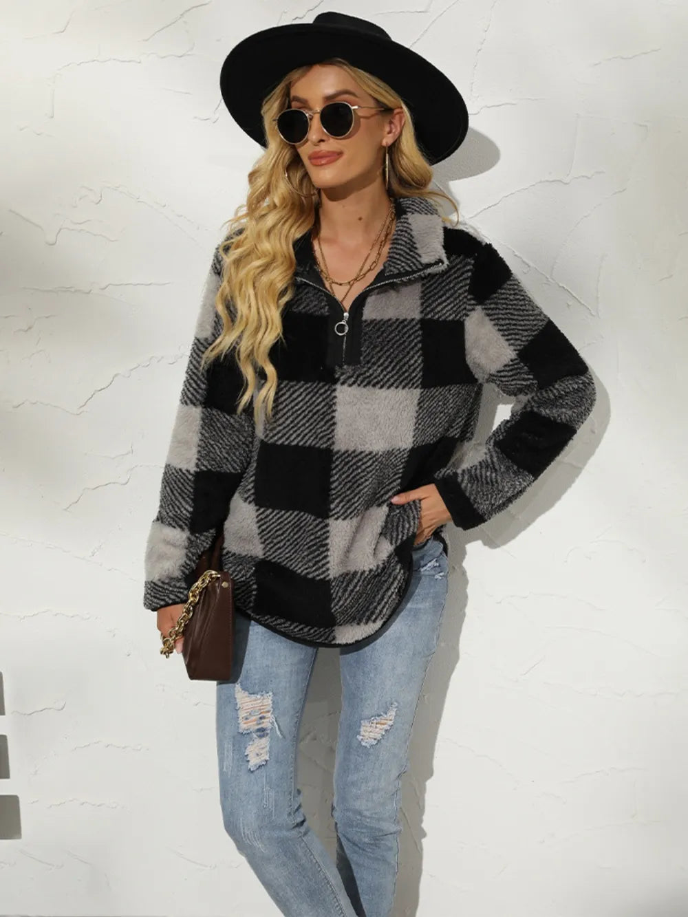 Model styling plaid half-zip sweatshirt with jeans and crossbody bag