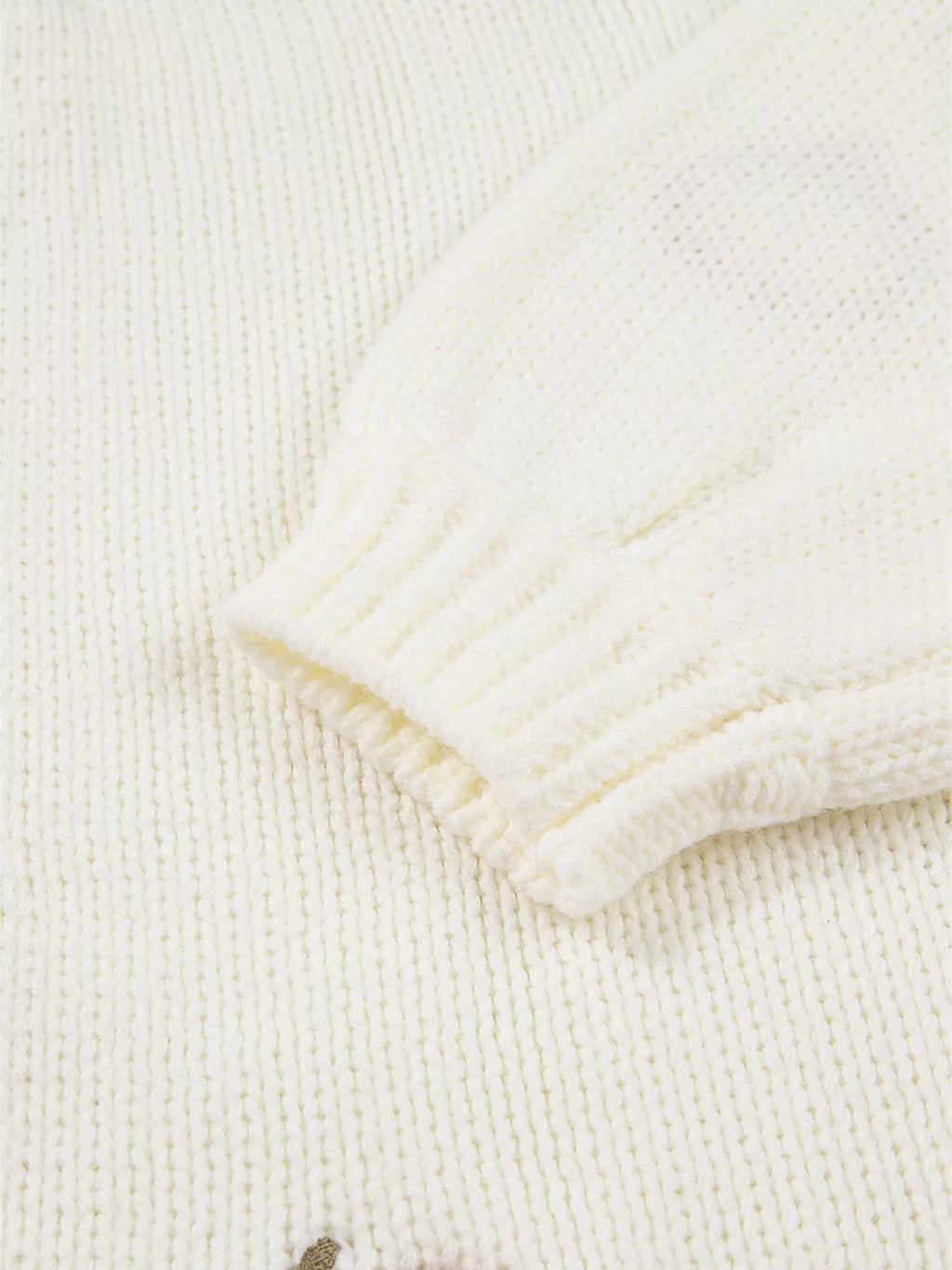 Detail of sleeve and knit texture of pumpkin embroidered cardigan