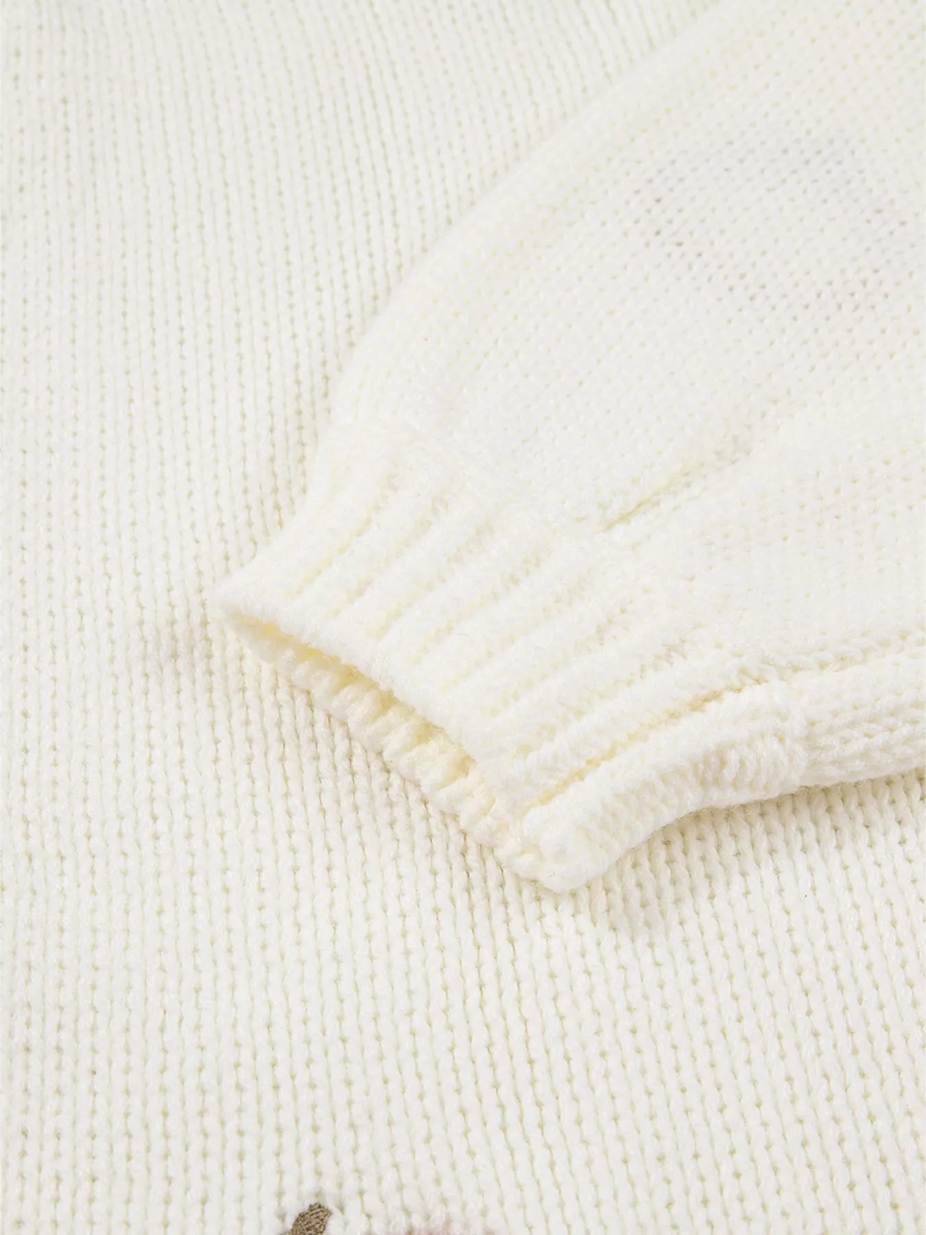 Detail of sleeve and knit texture of pumpkin embroidered cardigan